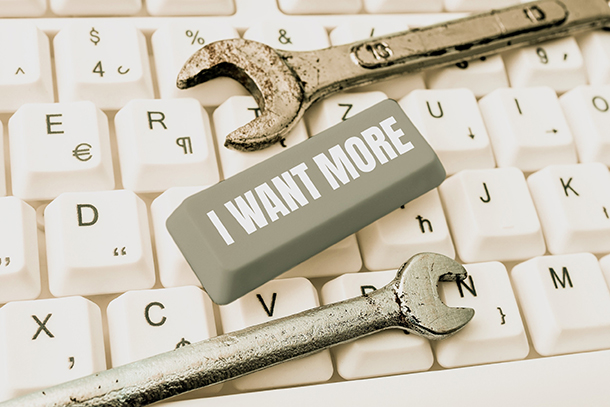 « I WANT MORE », écrit sur une touche de clavier, posée sur un clavier blanc et accompagnée de 2 clés à œillet